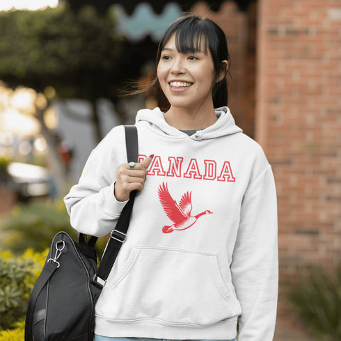 This hoodie celebrates the Canadian goose, wings spread wide, flying across Canada (and probably plotting its next lawn invasion).
